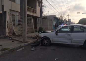 Auto se estrella con portón de casa y con poste