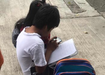 Hermanitos toman sus clases “ganchados” a internet en la calle
