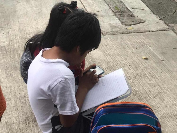 Hermanitos toman sus clases “ganchados” a internet en la calle