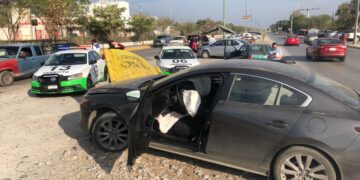 Automóvil se trepa a señal informativa