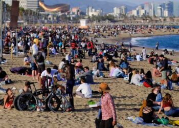 Turistas omiten restricciones por covid en playa de Barcelona