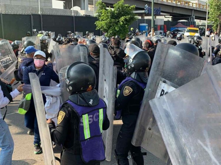 Contienen manifestación de expolicías que protestan frente al AICM