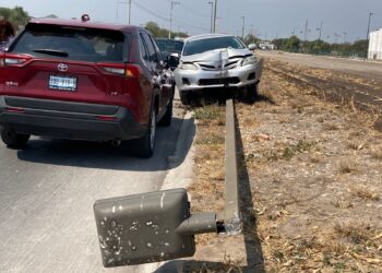 Joven conductor tumba luminaria con automóvil