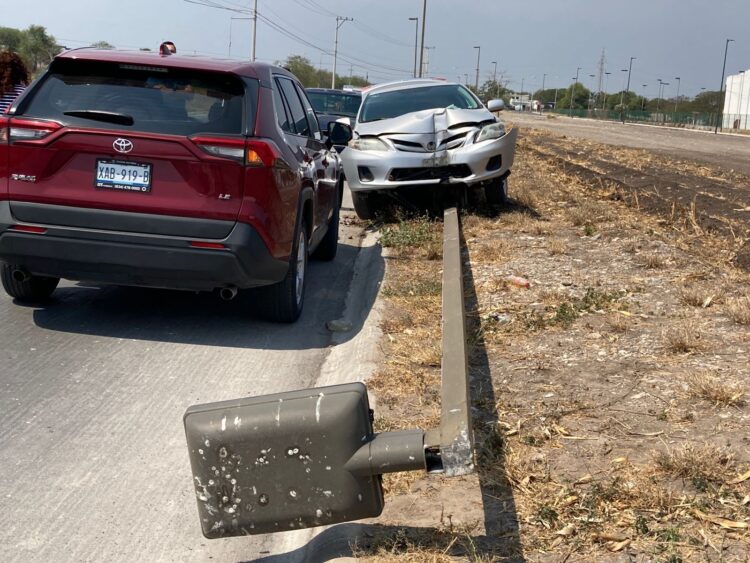 Joven conductor tumba luminaria con automóvil