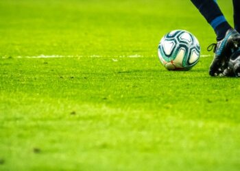 Una persona jugando fútbol en un campo