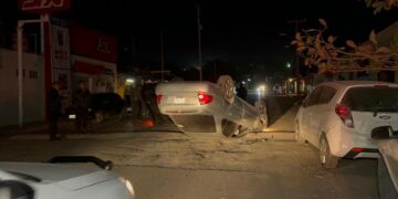 Termina volcado tras chocar autos estacionados