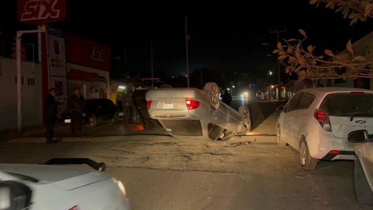 Termina volcado tras chocar autos estacionados