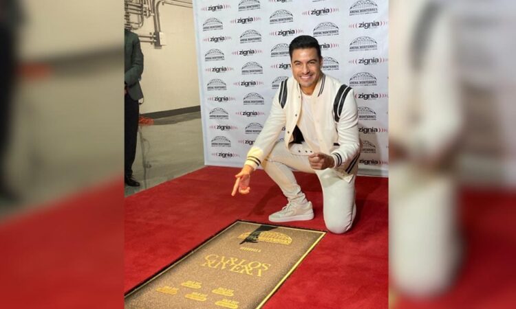Carlos Rivera celebra con una placa en la Arena Monterrey